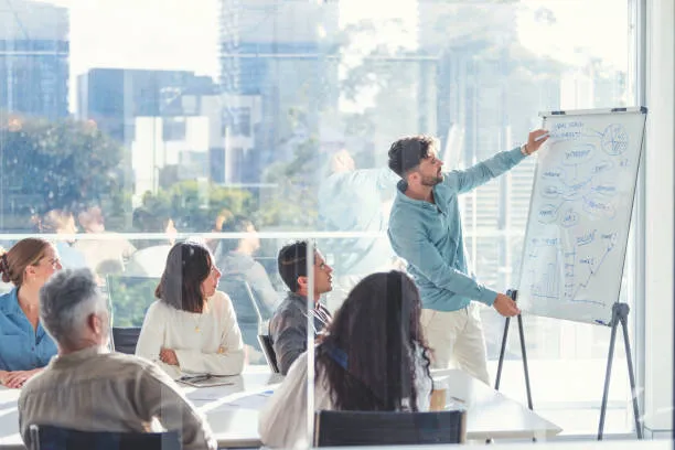 Imagen de un especialista en brindar cursos de capacitación que se encuentra dándolos al equipo de trabajo de una empresa.