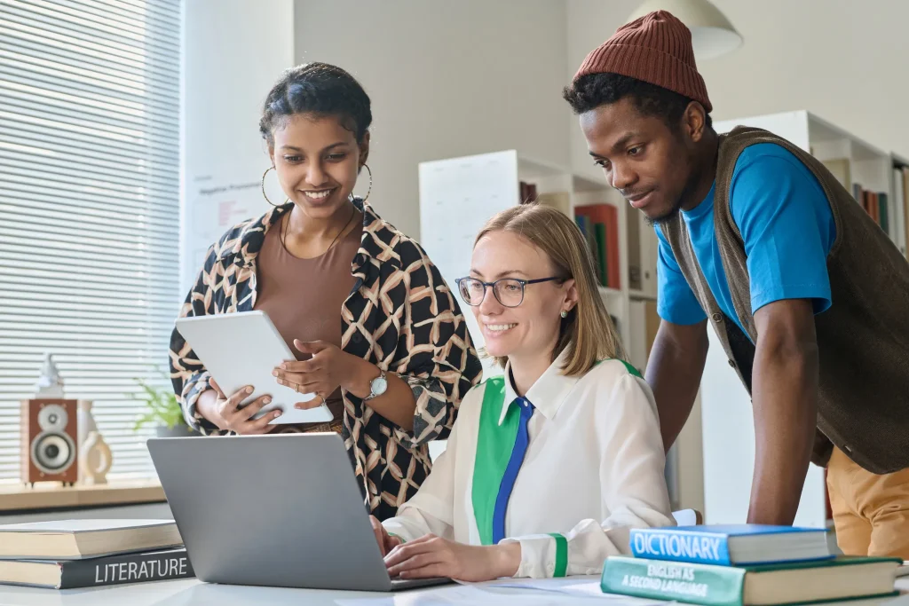 Están hablando del proceso de upskilling, tres personas que están viendo la pantalla de una computadora