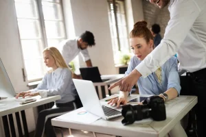 Frente a unas computadoras hay unas mujeres que les están explicando sobre upskilling