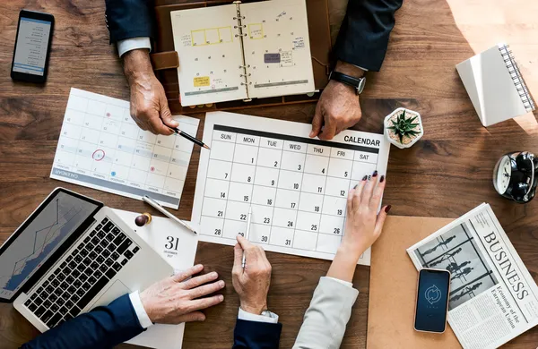 Manos alrededor de un calendario para planificar cuando se paga el aguinaldo